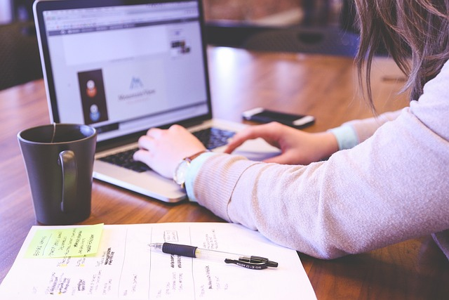 a person with a mug using a computer 