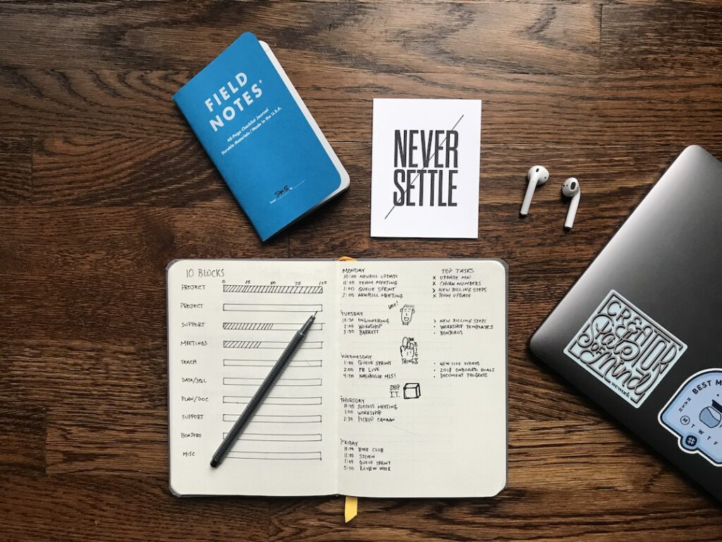 a notebook with a never settle card